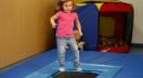 Little girl jumping on a mat trampoline