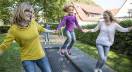 Little girl is jumping on a Eurotramp playground trampoline track called Kids Tramp Track Playground with two kindergarten teachers