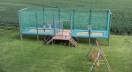 Trampoline set stationary with two fields and kids jumping on it