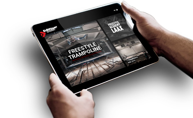 Picture of two hands holding an iPad showing the new Eurotramp Freestyle website.
